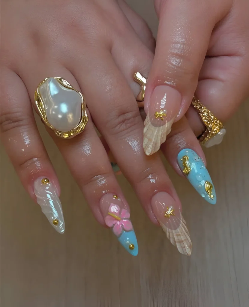 Intricate almond nails with 3D seashell textures, pastel blue accents, a pink 3D flower, and gold embellishments.