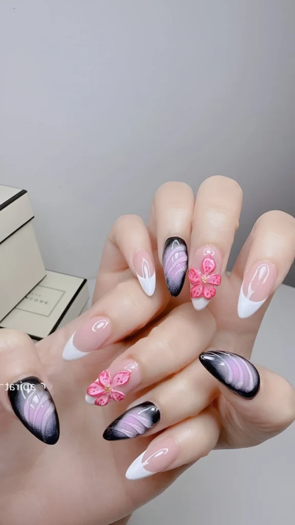 Statement manicure mixing white French tips, black/lilac magnetic effect, and 3D pink flowers on almond nails.