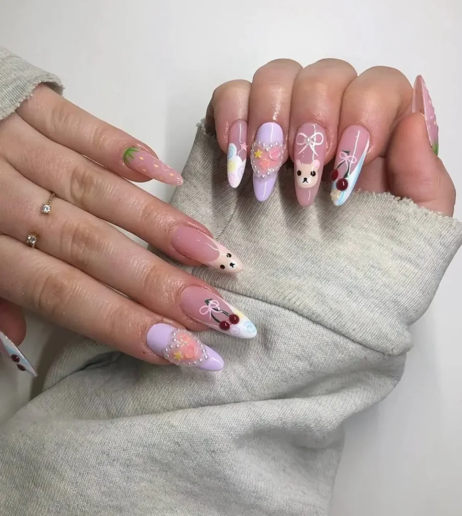 Long almond nails with a mix of cute pastel designs including lilac polish, cartoon faces, cherries, bows, and creative French tips.