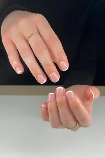 Short squoval nails featuring a crisp micro French manicure with a sheer base and thin white tips.