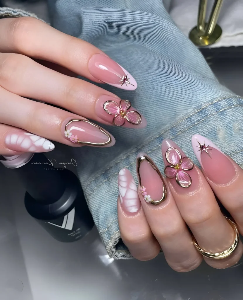 Jelly pink nails with 3D translucent flowers outlined in gold and gold frame accents.