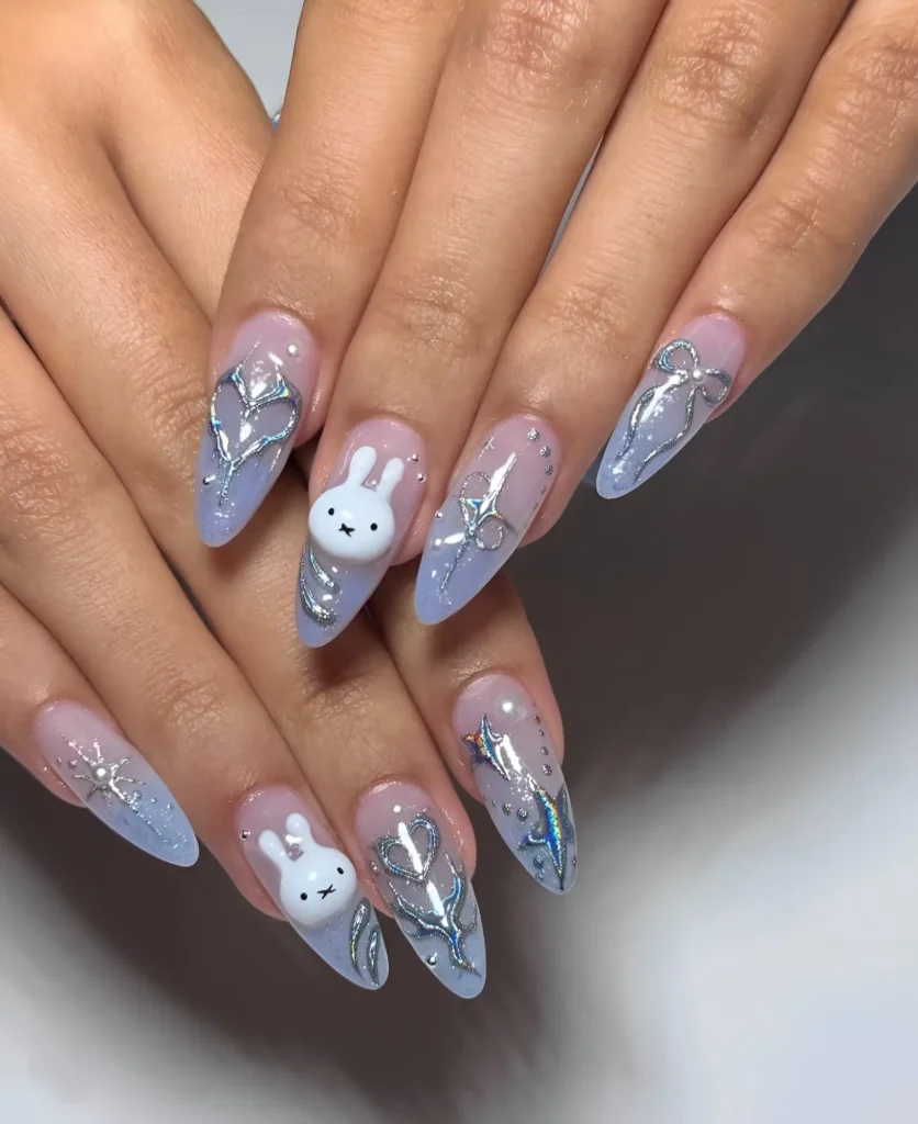 Long almond nails with lavender-blue base featuring 3D sculpted silver swirls, hearts, bows, and cute white bunny faces.