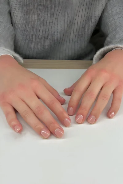 Short rounded nails painted with a classic opaque nude crème polish, a clean girl staple.