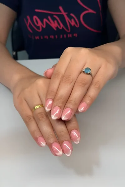 Medium oval nails with an opaque pink base outlined with a thin white border for a graphic clean manicure.
