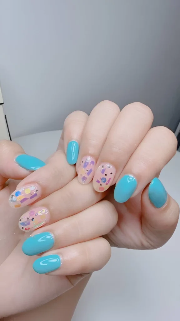 Bright turquoise nails mixed with accent nails showing colourful chunky confetti glitter over a sheer base.