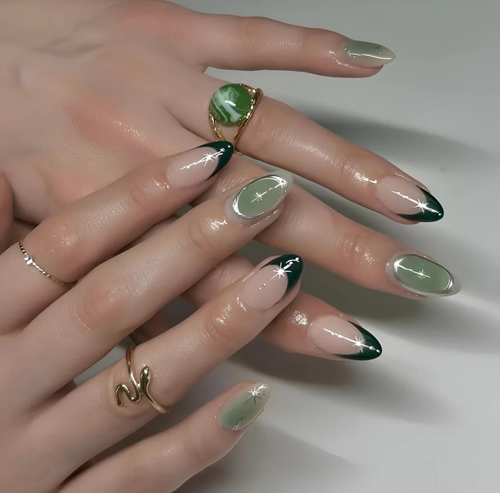 Sophisticated green manicure with forest green French tips, sage green nails outlined in chrome, and chrome starburst details.