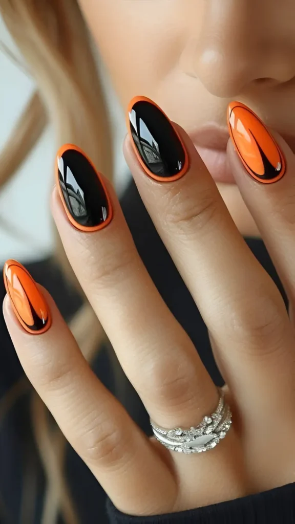Oval nails with a bright orange base and a glossy black overlay, leaving an orange outline visible around the edges.