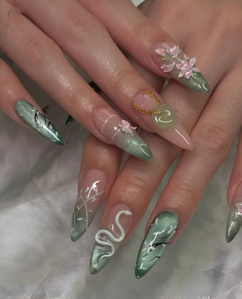 Enchanted garden nail art with shimmery green base, white snake, branches, and pink 3D flowers.