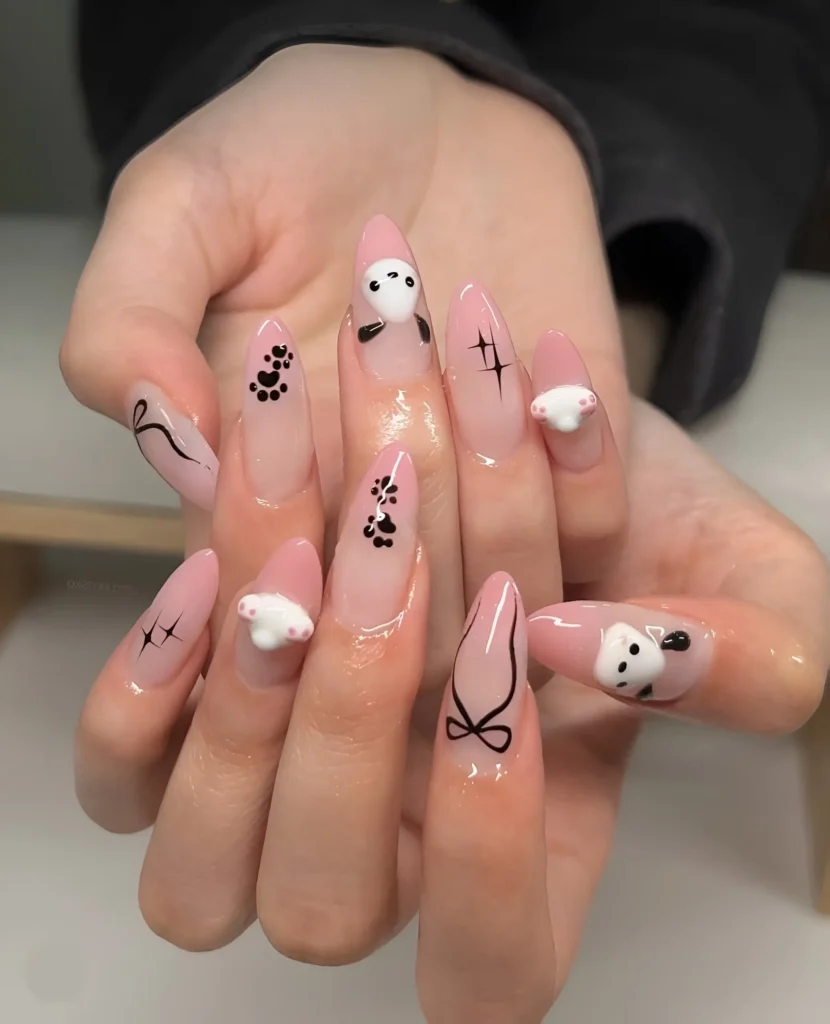 Almond nails with pink base featuring cute panda faces, black paw prints, line art bows, and sparkle drawings.