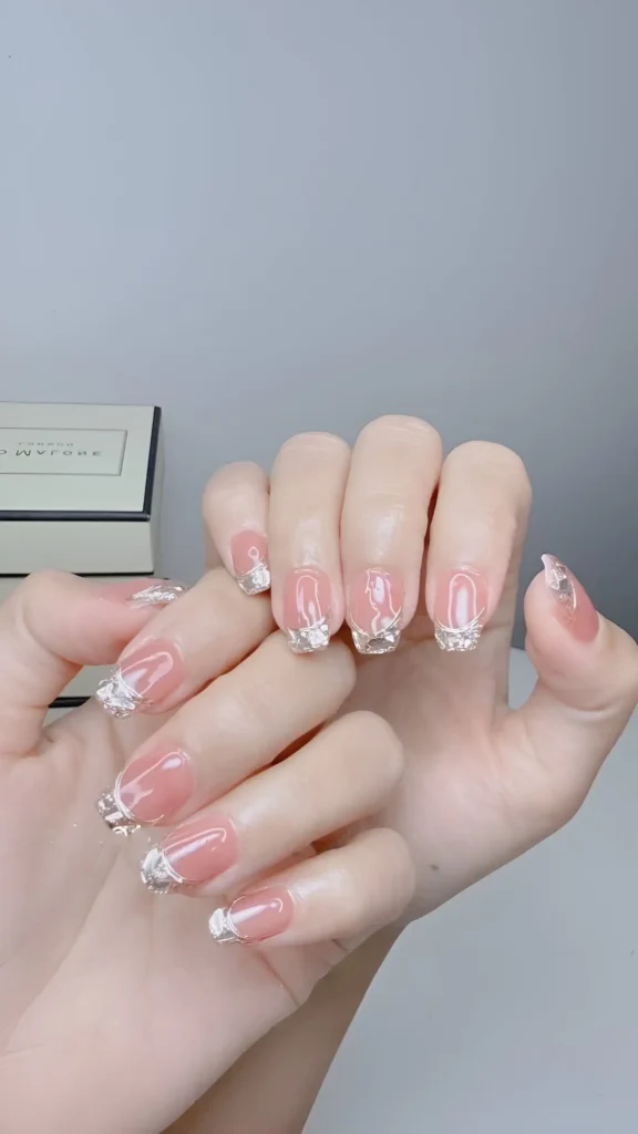 Luxurious crystal French manicure with tips made of densely packed micro-crystals on a sheer nude base. A glamorous classy nail idea.