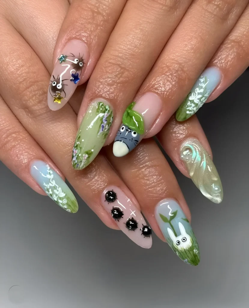 Detailed illustrative nail art depicting anime characters (Totoro, Soot Sprites) in nature scenes on almond nails.