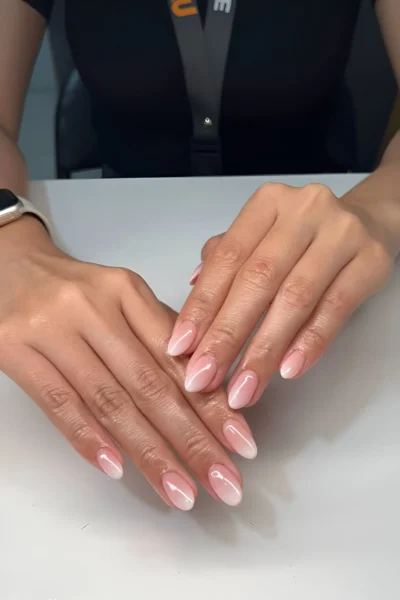 Medium oval nails with a seamless ombré French or baby boomer manicure blending sheer pink to soft white.