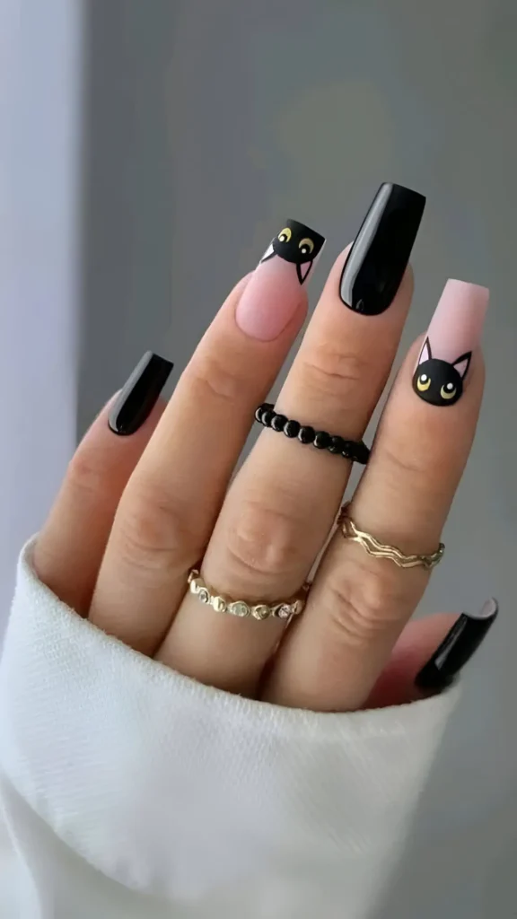 Coffin-shaped nails with a mixed design including solid glossy black and matte pink nails featuring a black cat head motif with yellow eyes.