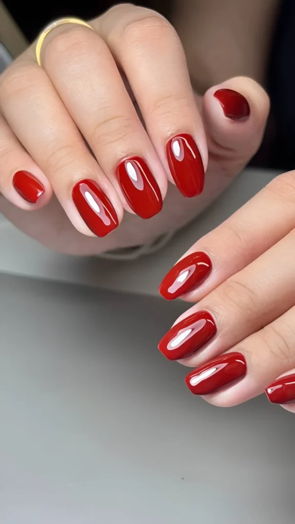 Simple red nail ideas: classic glossy deep red polish on medium rounded nails.