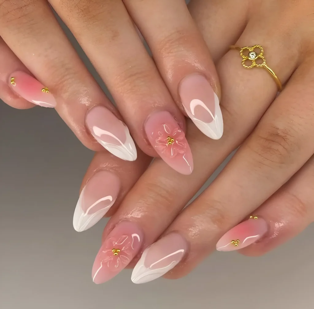 Almond nails mixing white French tips on sheer base with solid pink nails featuring 3D pink flowers and gold stud accents.