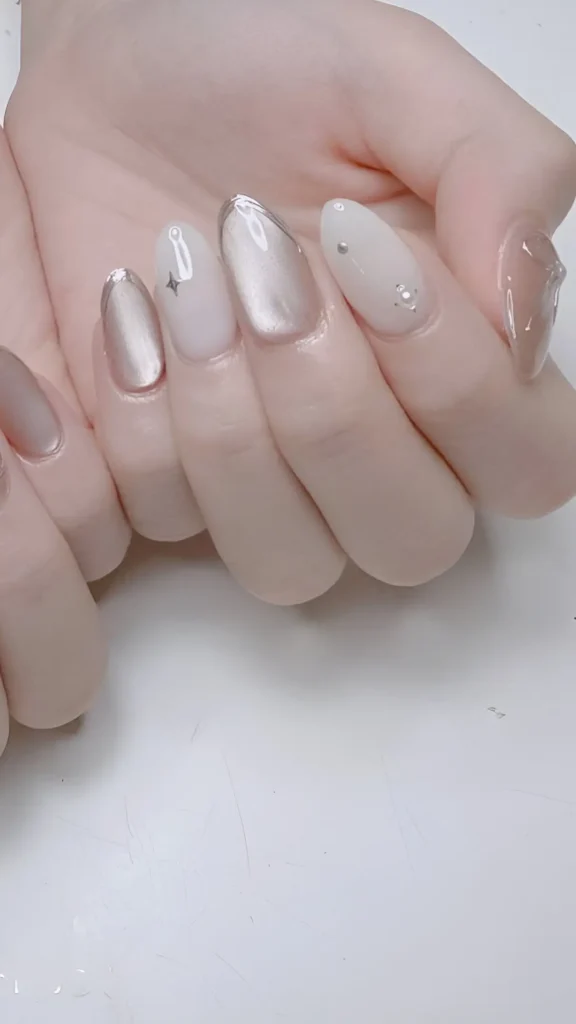 Sophisticated neutral manicure mix: champagne shimmer, milky white with stars, silver chrome lines, and 3D clear gel texture. Provides versatile classy nail ideas.