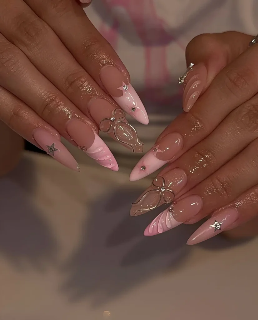 Ethereal stiletto nails with large clear 3D crystal bow/butterfly charms, soft pink swirls, and rhinestone accents.