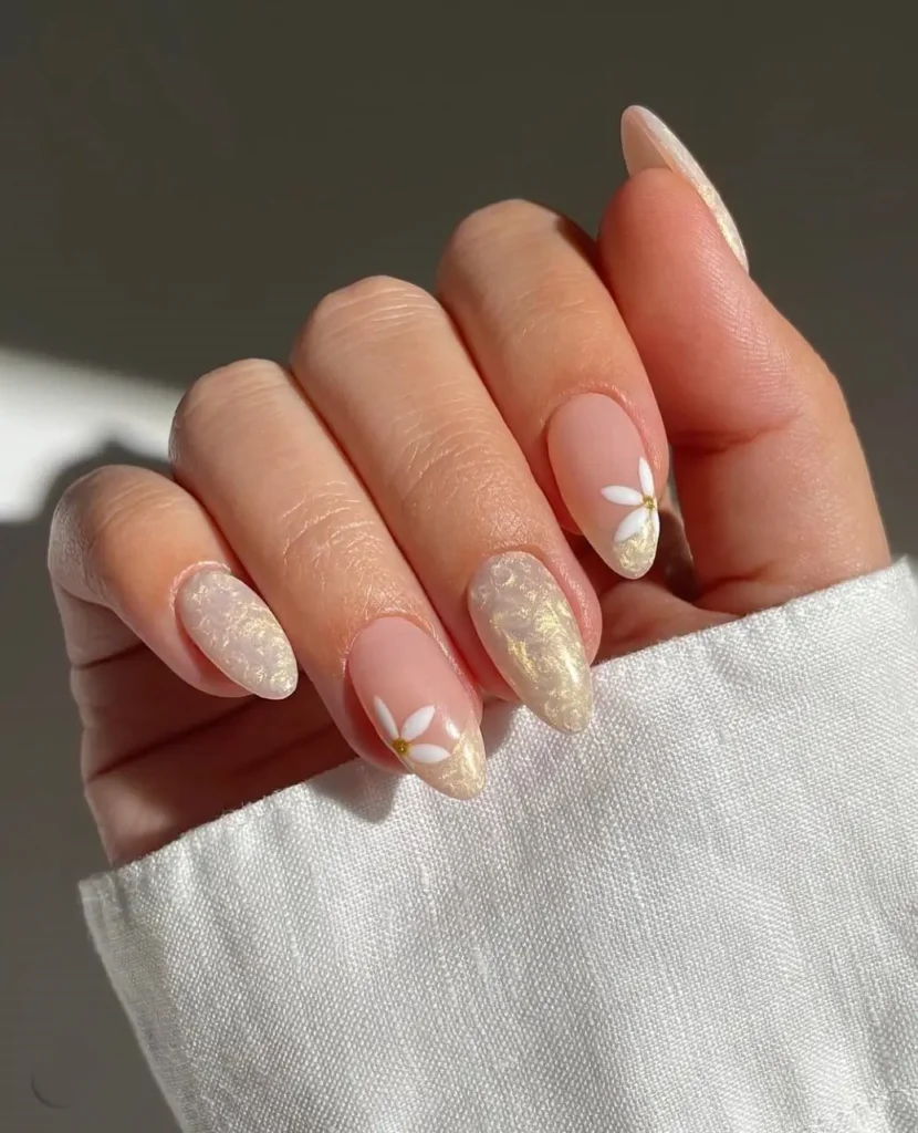 Elegant almond nails mixing full-coverage pearlescent shimmer finish and simple white daisy accents on sheer base.