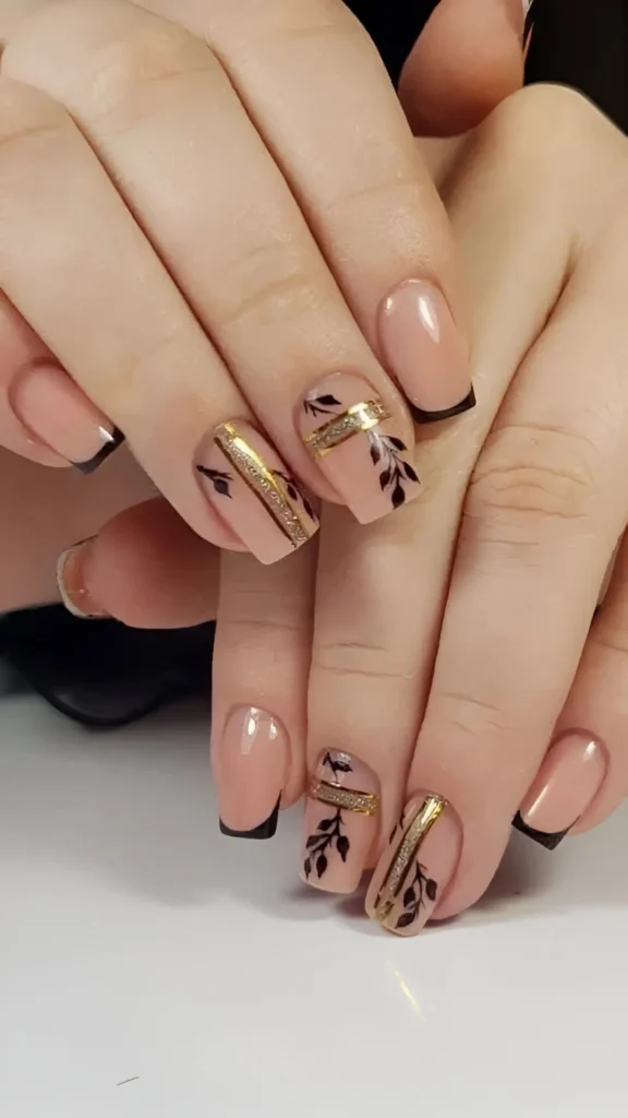 Short square nails with mixed design: micro black French tips and sheer nails with a central gold glitter band framed by black botanical illustrations.