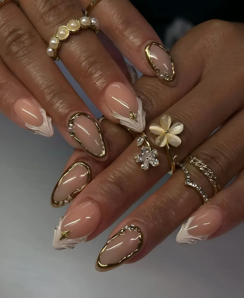 Ethereal almond nails with abstract white shapes outlined in prominent gold, accented with celestial details.
