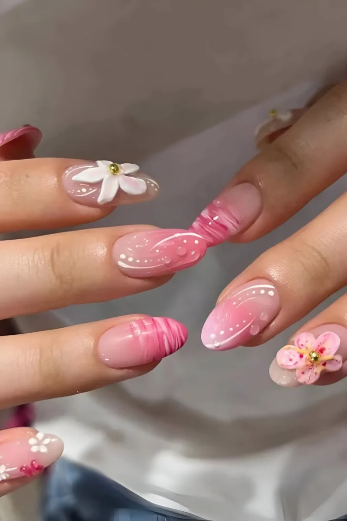 Cute pink nail design with ombre, pink swirls, white dots, and 3D flowers.