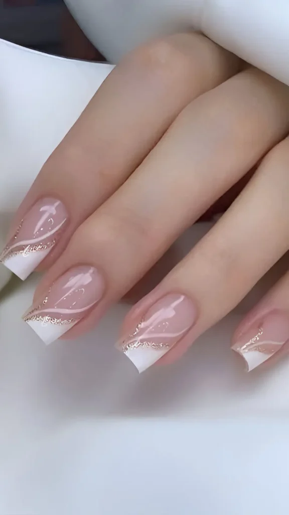 Cute pink sheer nail design with modern angled white French tips and gold glitter line accent.