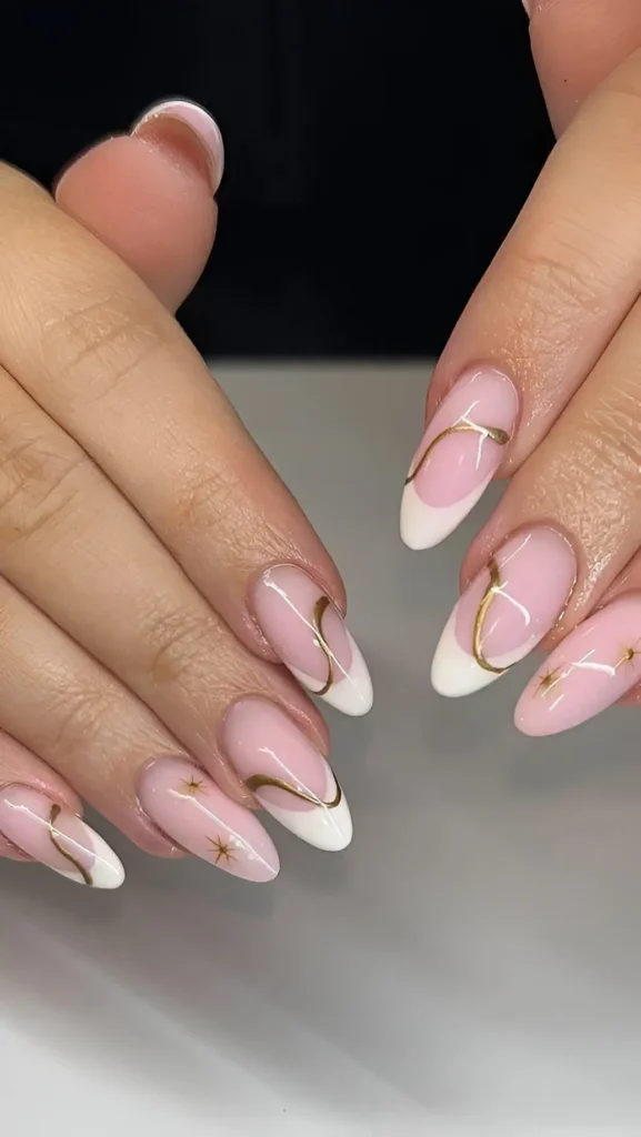 Cute pink base French manicure with white tips and elegant gold swirl line accents.