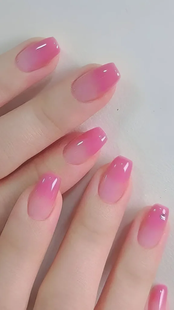 Cute pink ombre nail design with sheer base fading to jelly pink tips.