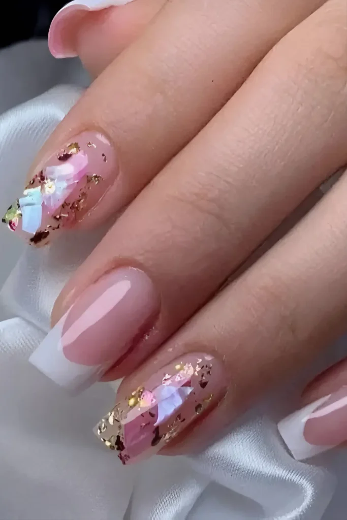 Cute pink nail design with embedded iridescent shards, gold foil flakes, and white French tip.