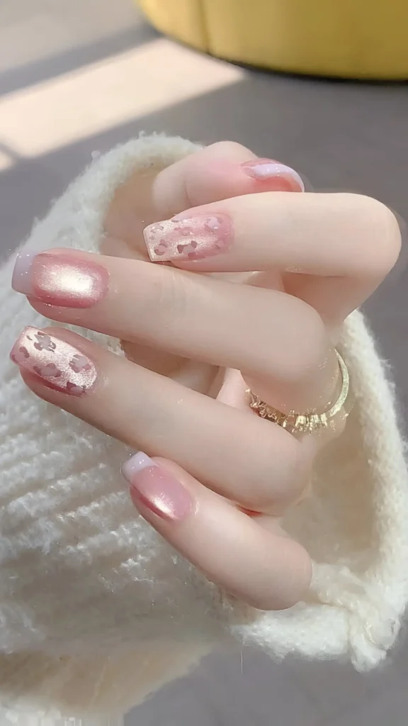 Cute metallic chrome pink nail design with abstract spots and classic French tip accent.