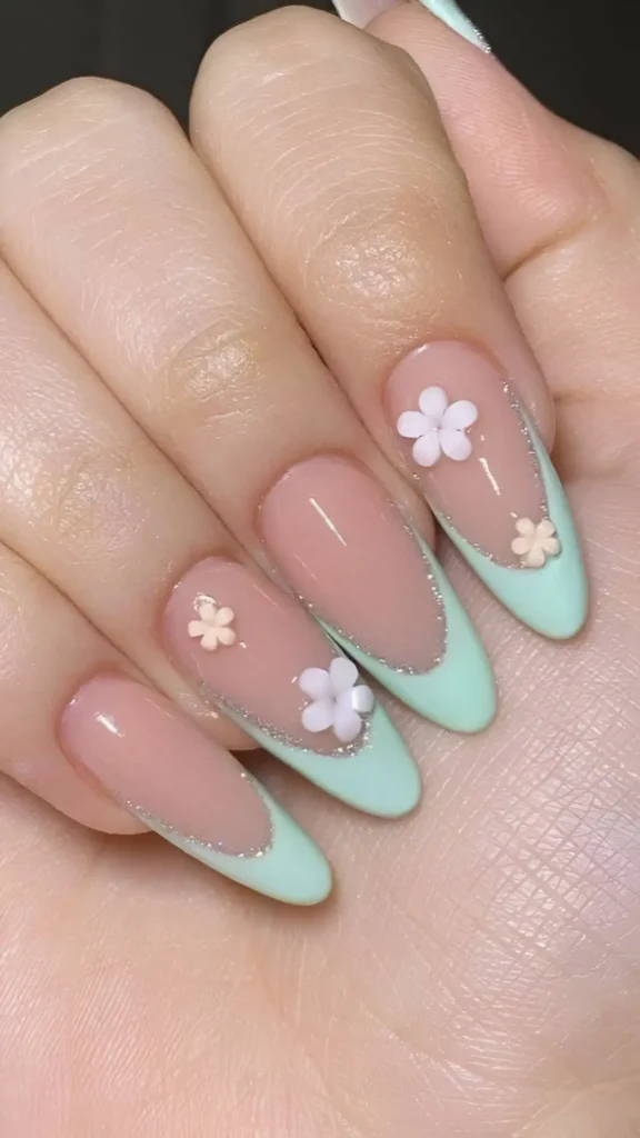 Cute pink base French manicure with mint green tips, silver glitter line, and 3D flowers.