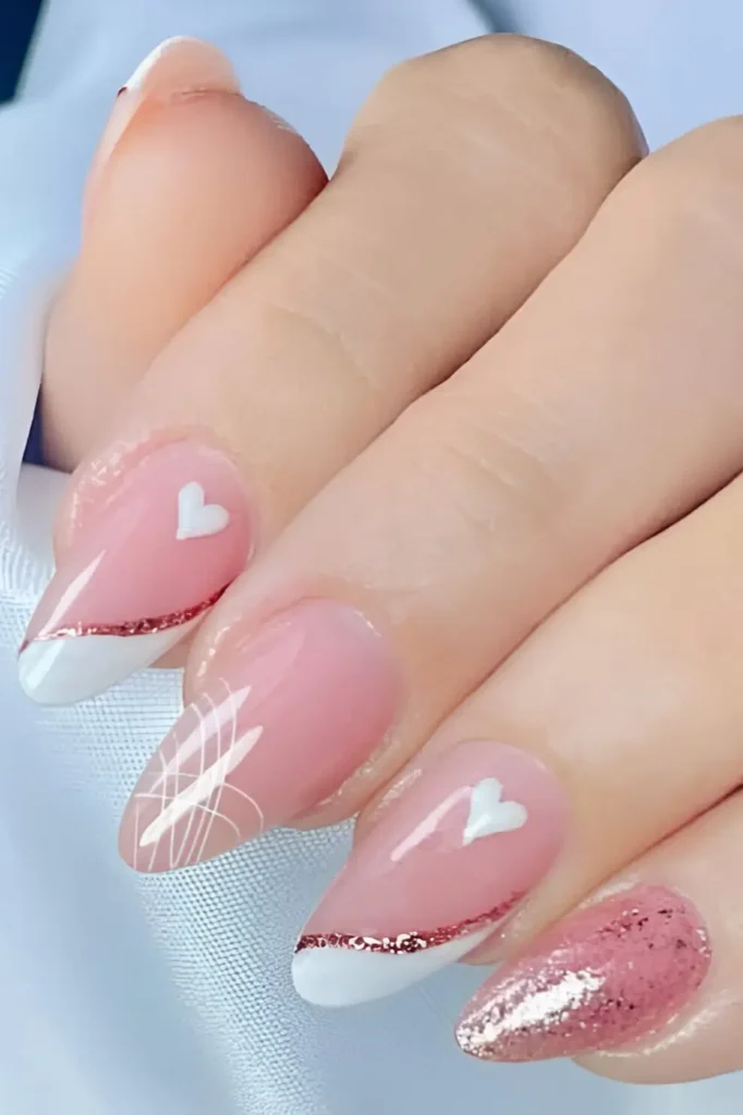 Cute pink nail design mix with white angled French tips, rose gold glitter, white hearts, line art, and pink glitter nail.
