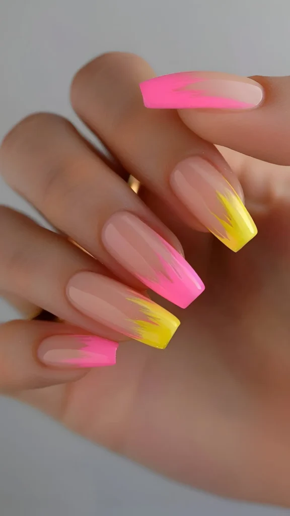 Cute pink base nail design with neon pink and neon yellow abstract flame tips.