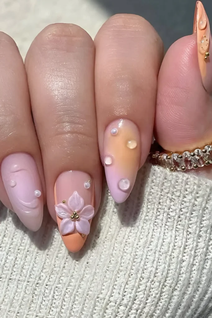 Cute pastel pink/lilac and peach ombre nail design with 3D flower and clear water droplet accents.