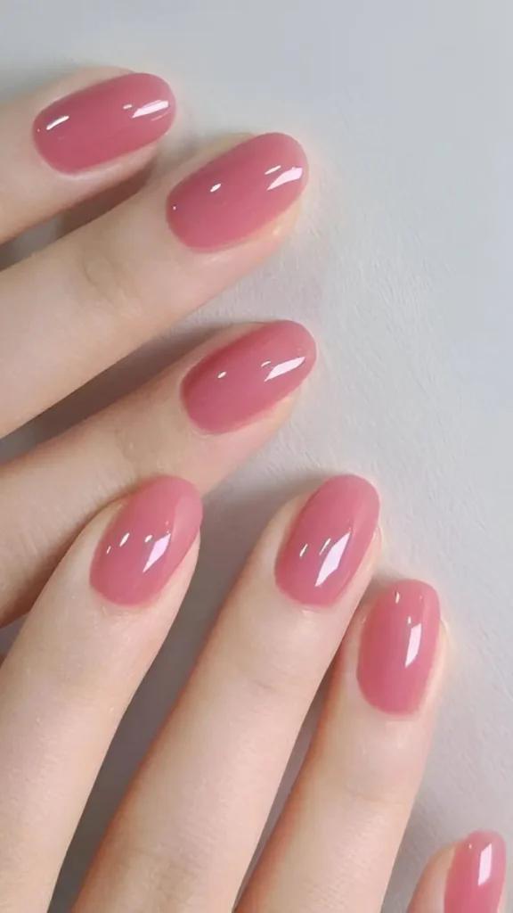 Cute solid rose pink glossy nail design on medium oval nails.