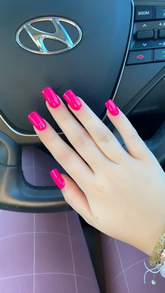 Cute vibrant hot pink solid color nail design on medium square nails.