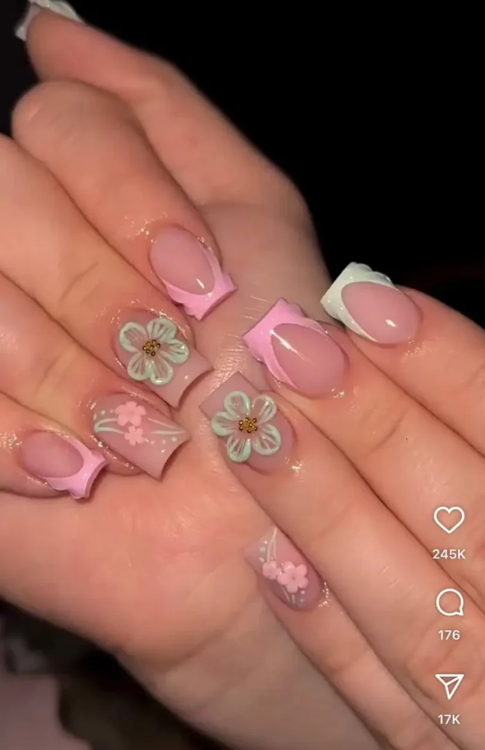 Detailed summer nail idea: 3D pastel flowers on pink nails with framed French tips and dot accents.