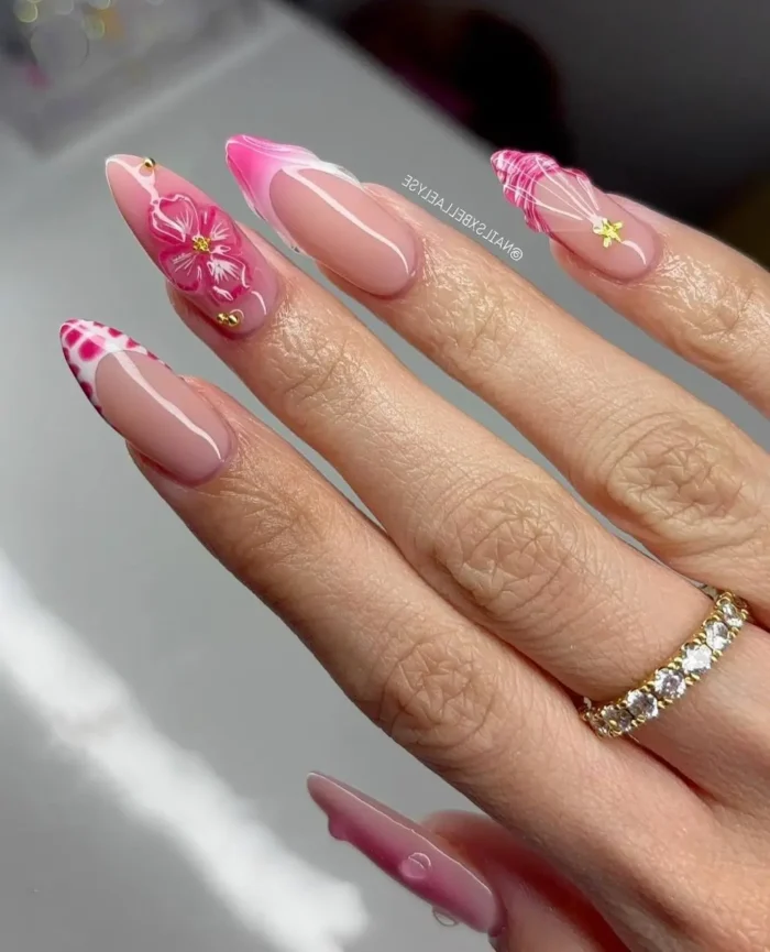 Trendy summer nail art on almond nails with a mix of pink patterns including floral, cow print, and gingham.
