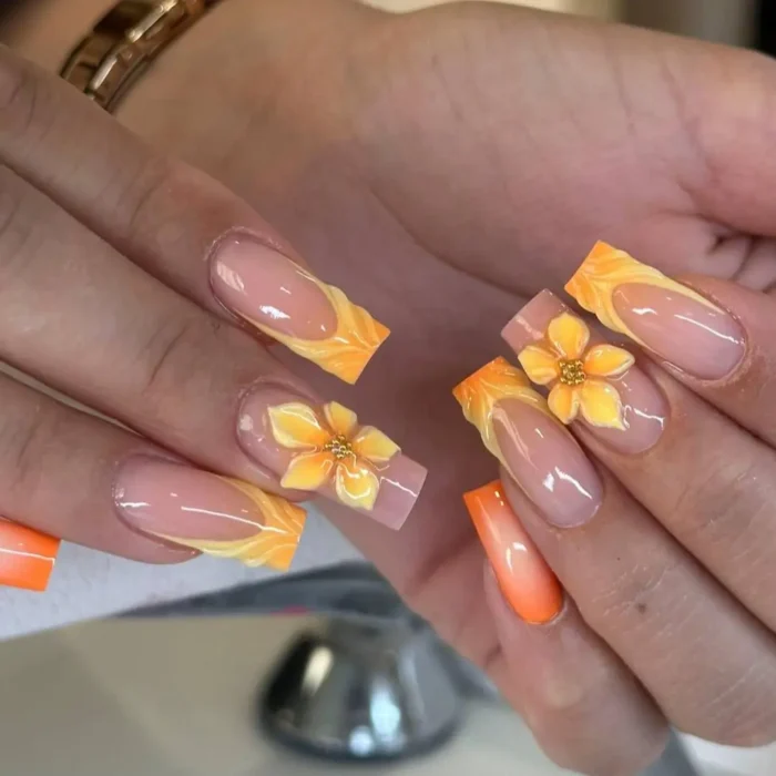 Long coffin nails with 3D yellow sunflowers and sculptural orange and yellow French tips.