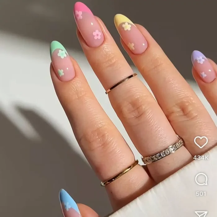 Almond-shaped nails with multi-color pastel French tips and tiny cute daisy flower details.