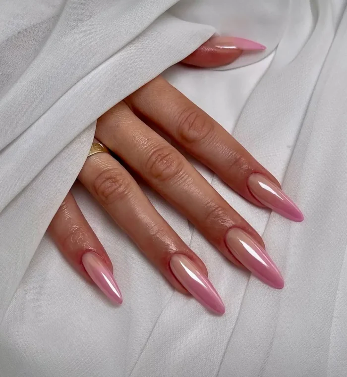 Cute simple gel nail idea with a luminous vibrant pink aura effect on long stiletto-shaped nails.
