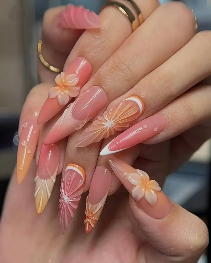Refreshing summer nail art on long stiletto nails with a citrus theme, featuring 3D orange and peach slices and dewdrop accents.
