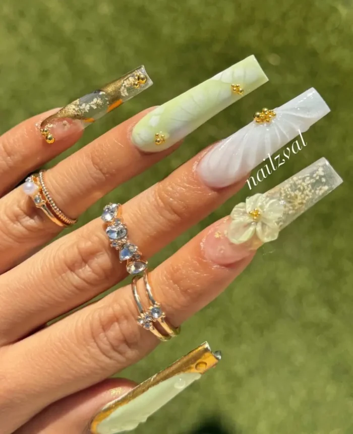 A luxurious, gallery-worthy manicure with a mix of green marbling, gold leaf, and intricate 3D sculpted floral details.