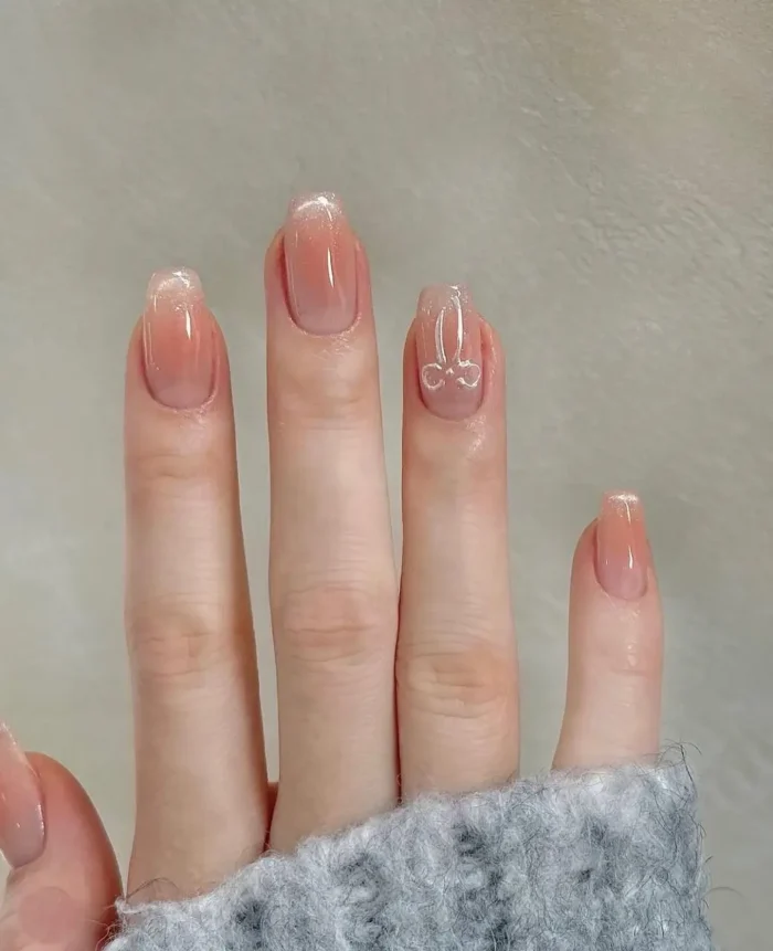 Short square nails with a sheer base, featuring a 3D metallic cherry charm on the ring finger accent nail.
