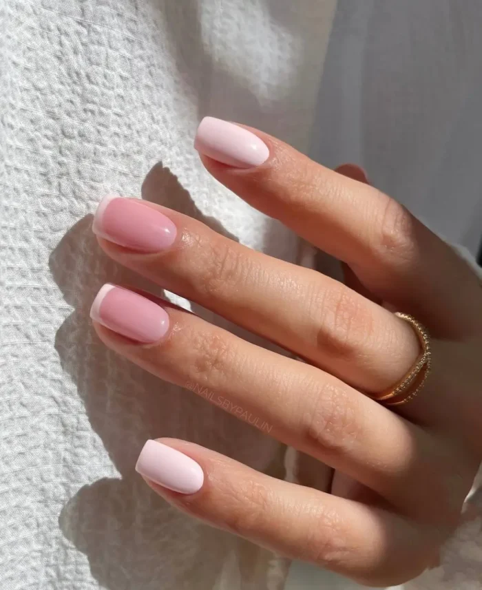 Short, squoval nails with a balanced mix of classic white French tips and solid light baby pink polish.
