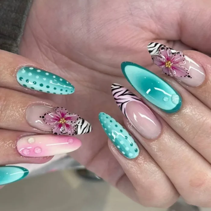A mismatched almond nail set featuring teal, polka dots, zebra print, and a 3D pink flower with water droplet accents.