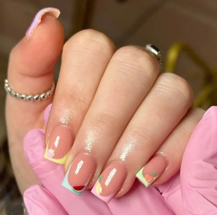 Short square nails with colorful French tips featuring cute summer fruit art designs like watermelon and citrus.