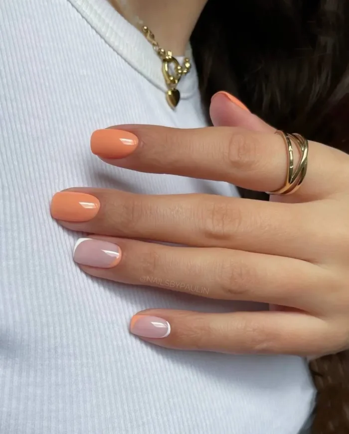Classic French tip nails updated with a warm peach shade on the tips, set against a natural nude base.