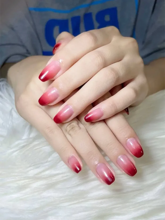 Cute simple gel manicure with a bold classic red ombre fade on medium almond-shaped nails.