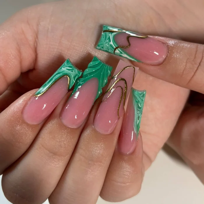 Long square/coffin nails with vibrant green marbled French tips in a sharp geometric style, accented with fine abstract gold lines on a sheer pink base.